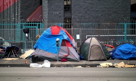 A tent-lined street littered with garbage where homeless live