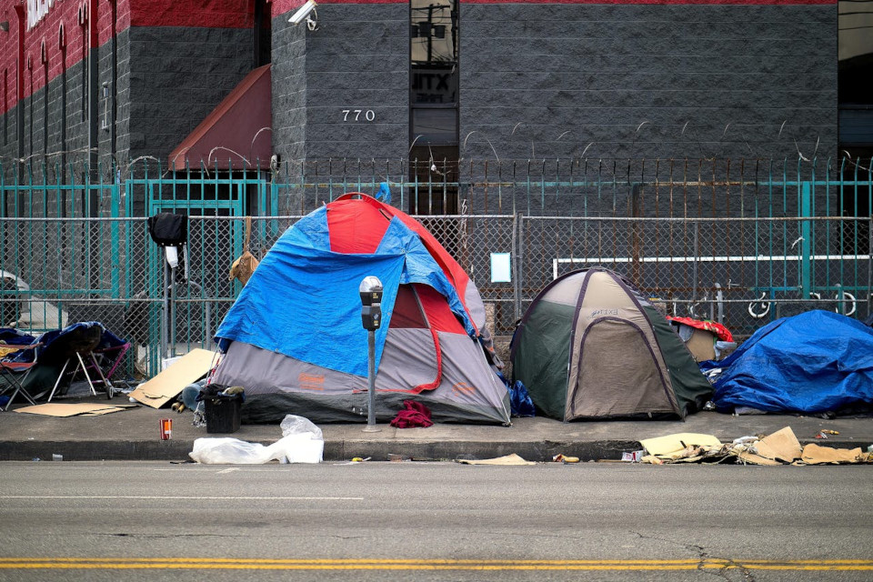 A tent-lined street littered with garbage where homeless live